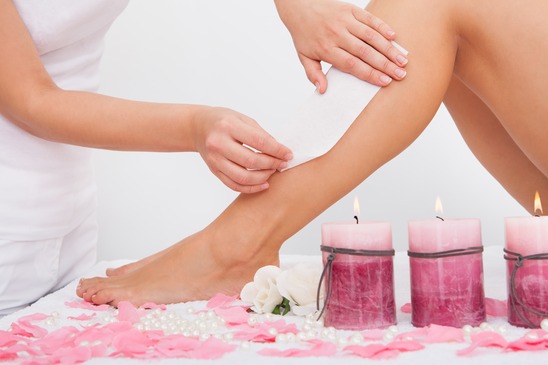 Beautician Waxing A Woman's Leg